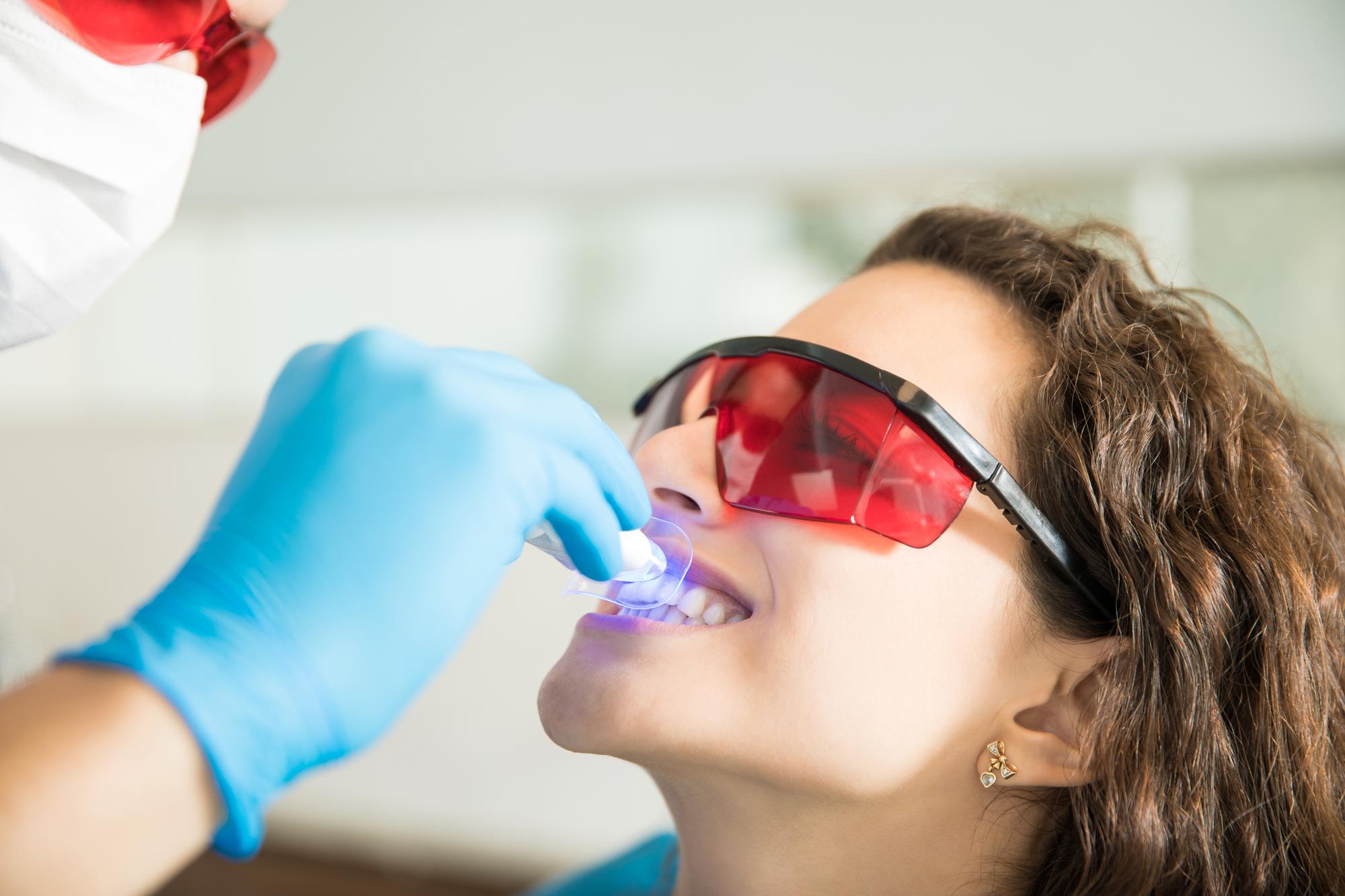 closeup-young-woman-having-her-teeth-whitened-with-ultraviolet-light-dental-clinic